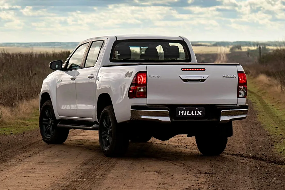 Toyota Hilux blanca vista desde atrás en un camino de tierra